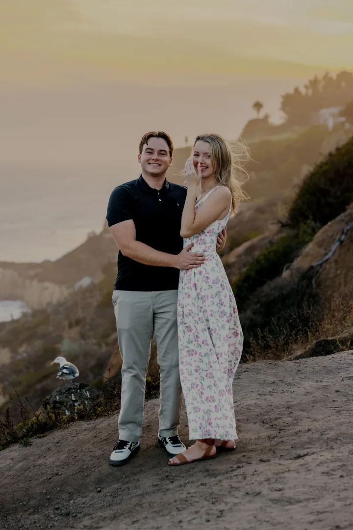 Kayley and Jack smiling toward the camera on the coastal path