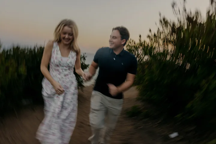 Kayley and Jack holding hands in a softly blurred walking photograph