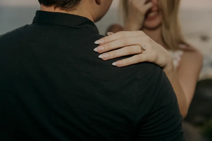 Close-up of Kayley's engagement ring as her hand rests on Jack's shoulder