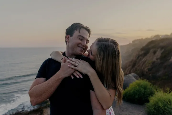 Kayley kissing Jack's cheek on the coastal bluff