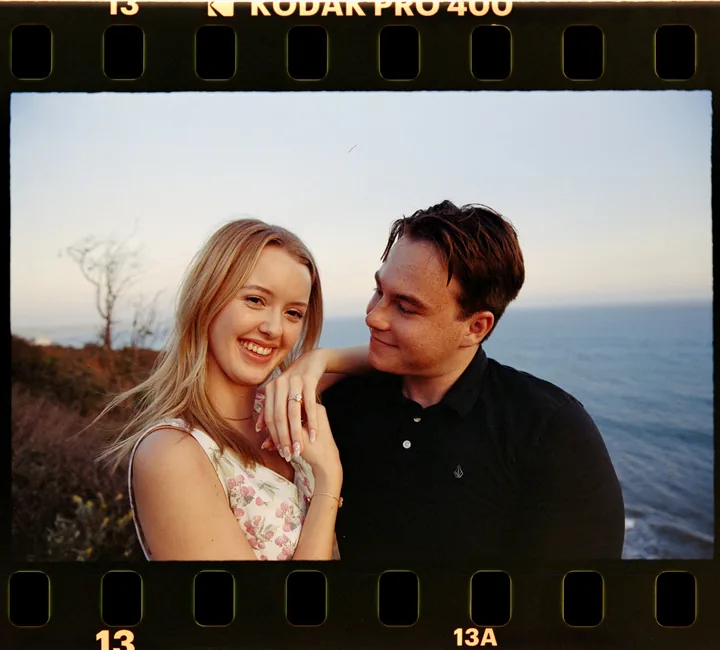 Film-framed portrait of Kayley smiling as Jack looks toward her