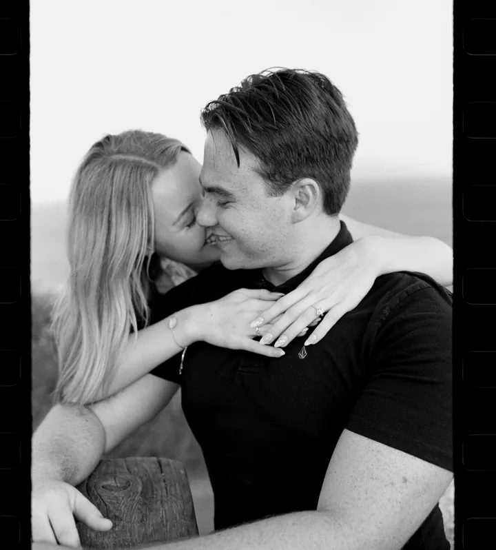 Black-and-white framed portrait of Kayley and Jack embracing cheek to cheek
