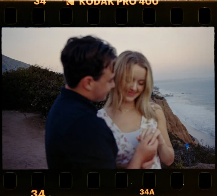 Film-framed photograph of Kayley looking down at their hands beside Jack