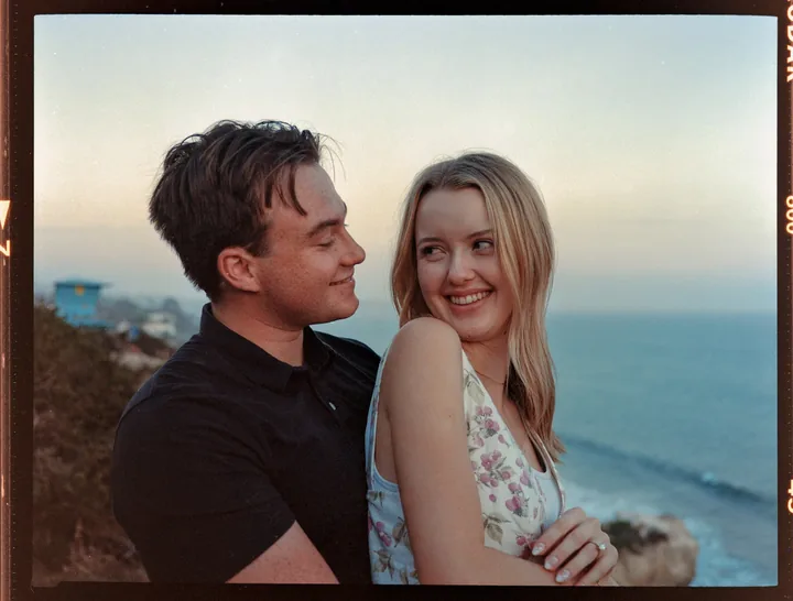 Framed portrait of Kayley smiling toward the camera beside Jack
